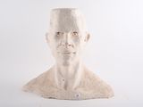 une sculpture blanche représentant un homme coiffé d'un chapeau