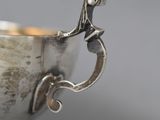 a silver cup that has a handle on it