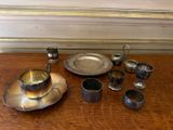une table en bois sur laquelle sont posés un plateau en argent ainsi que des tasses et des soucoupes en argent