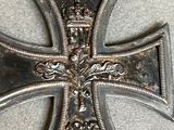 an old silver cross with a black ribbon on a table