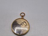 un cadenas doré sur lequel figure la photo d'un homme en costume-cravate