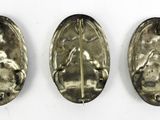 three pieces of silver are shown in a row on a white surface