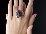 main d'une femme portant une bague en or sertie d'une pierre d'améthore