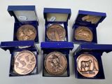 six different types of coins in a blue box on a white surface