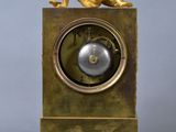 a gold clock with a statue on top of it