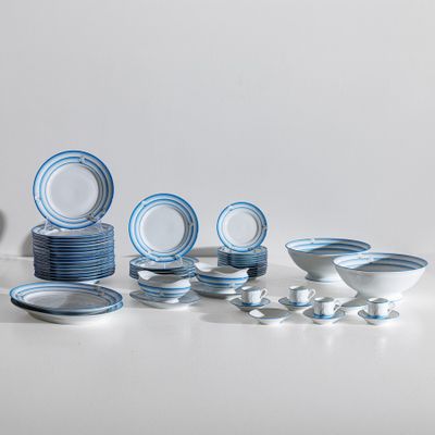 beaucoup d'assiettes et de bols bleus et blancs sur la table