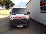a white van with a red and white stripe parked in front of a building