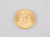 a close up of a gold coin on a white surface