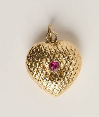 une image représentant un pendentif en or en forme de cœur orné d'une pierre rose