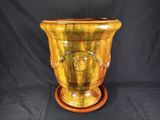 a yellow vase that is sitting on a wooden stand