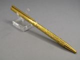 an image of a pen with a gold finish on a clear base