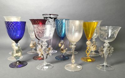 several different colored glass goblets are lined up on a gray surface
