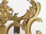 a gold sculpture on a stand on a white surface