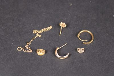 un gros plan sur une paire de boucles d'oreilles et une chaîne posées sur une table