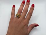 woman ' s hand with red manicured nails and a gold ring