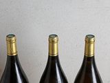 three bottles of wine sitting on a table next to each other