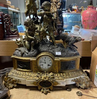 une horloge posée sur une table sur laquelle se trouve une statue