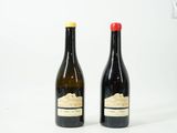 deux bouteilles de vin posées l'une à côté de l'autre sur une surface blanche