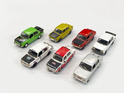 plusieurs petites voitures sont alignées sur une surface blanche