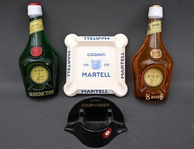 trois bouteilles d'alcool et un cendrier posés sur une table