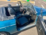 a blue car with a black leather seat in the parking lot