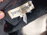 a close up of a person ' s hand holding a label on a jacket