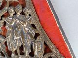 a silver metal object with a red ribbon around it