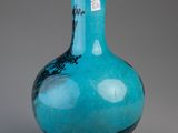 a blue glass vase with a black design on it