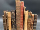 several old books stacked on top of each other on a table