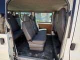 une camionnette blanche dont les portes sont ouvertes et les sièges rabattus