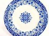 a blue and white plate on the table with a fork and knife