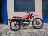 une moto rouge garée devant un immeuble