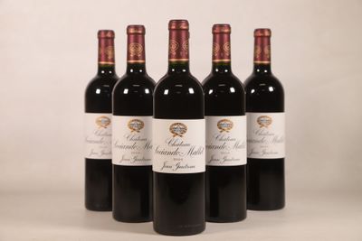 quatre bouteilles de vin rouge sont alignées