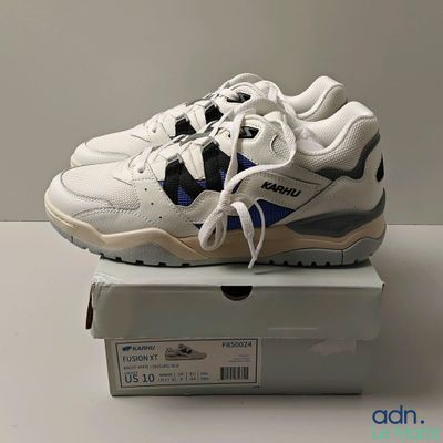 Il s'agit de deux paires de baskets blanches et bleues posées sur une boîte.