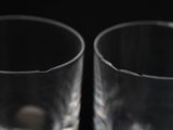 two empty glasses sitting next to each other on a table