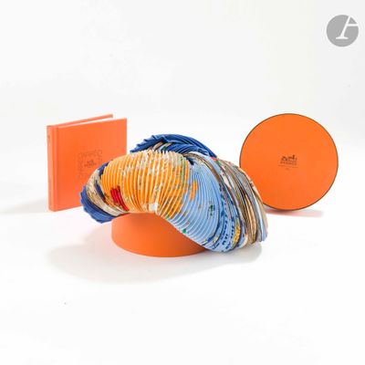 une boîte orange avec une écharpe bleue et orange et un bonnet bleu et orange