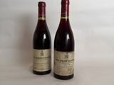two bottles of wine sitting on a table next to each other