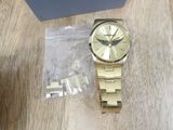 gold watch on a table next to a box of jewelry