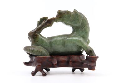 une statue représentant une grenouille assise sur une branche d'arbre