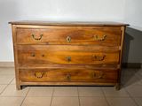 a wooden chest of drawers on a tiled floor