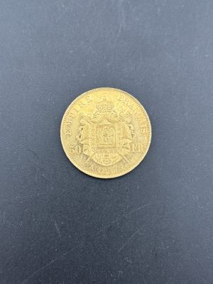 gros plan d'une pièce d'or sur une surface noire