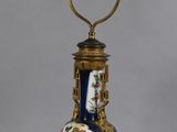 a blue lamp with a gold base and a blue vase on it