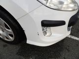 a close up of a white car parked in a parking lot