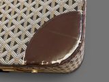 a brown and white purse sitting on top of a table