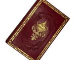 an old red book with gold trim on a white background