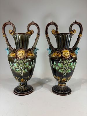 pair of antique vases with floral designs on them on a white surface