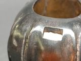 a small silver pot with a handle on a table