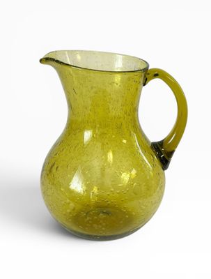 pichet en verre jaune avec une anse noire sur fond blanc