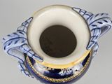a blue and white vase with a gold decoration on it