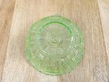 a green glass plate sitting on a wooden table